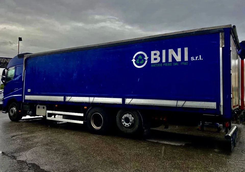 Un autoarticolato blu con il marchio Bini parcheggiato su un piazzale