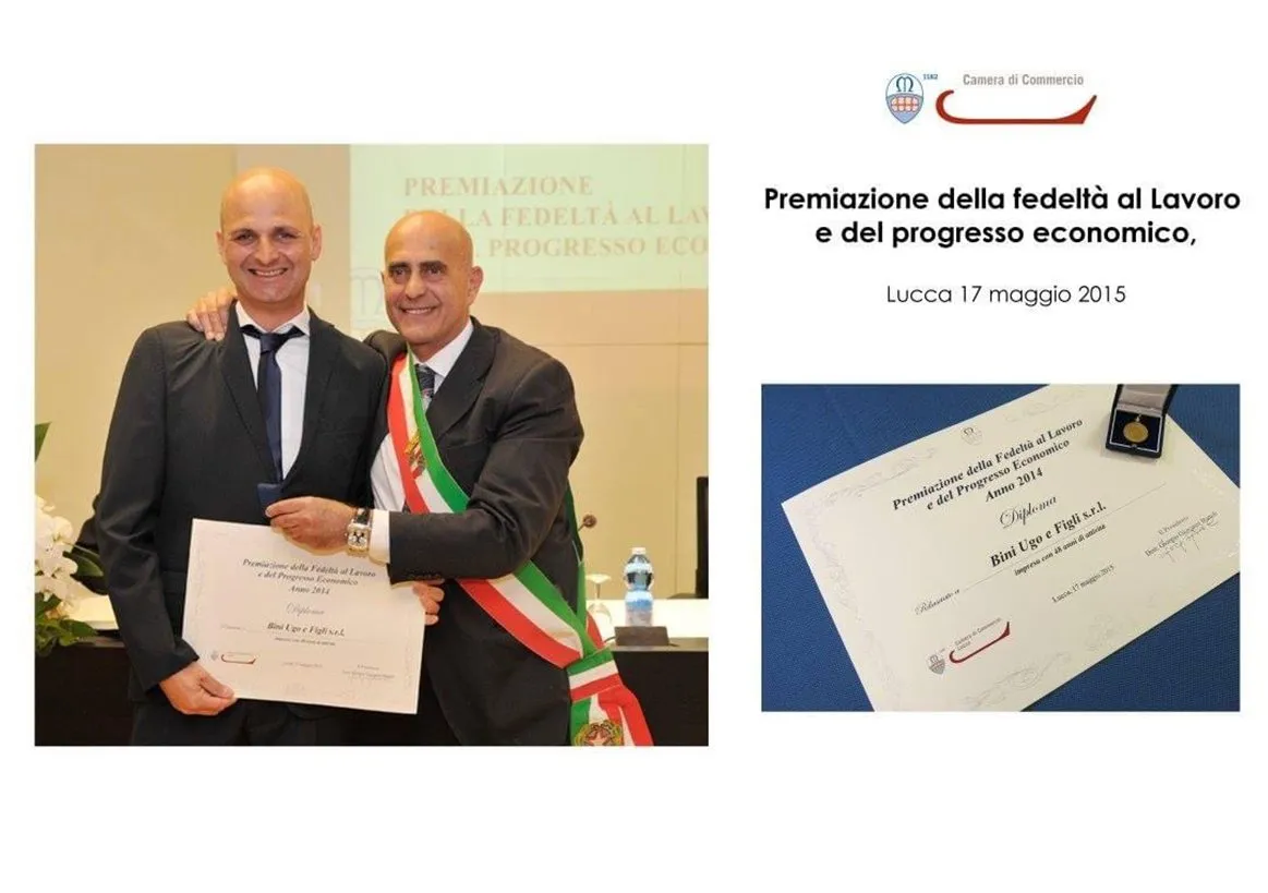 Luca Bini stringe la mano al sindaco con fascia tricolore, accanto al diploma