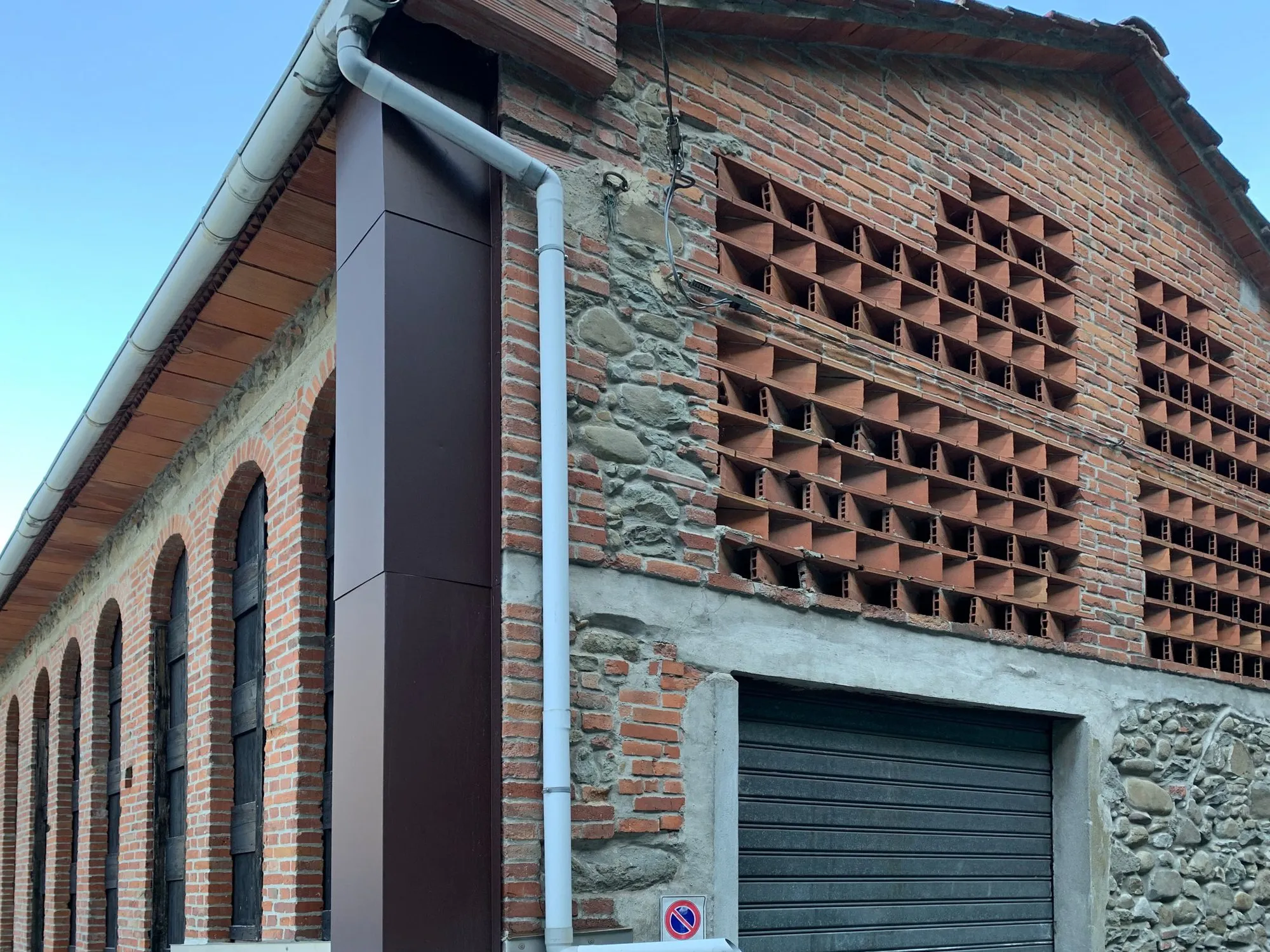 Facciata in mattoni e pietra con grate traforate della prima fabbrica di cartapaglia