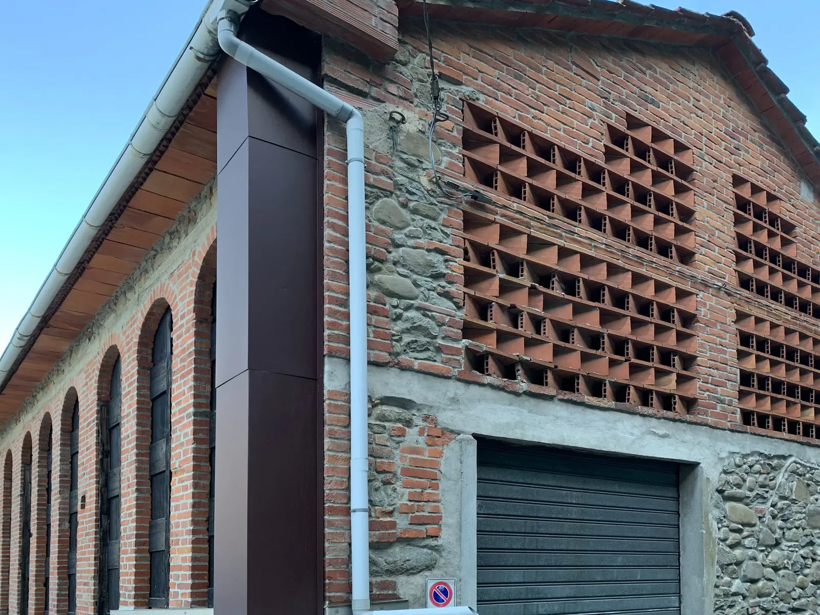 Facciata in mattoni e pietra con grate traforate della prima fabbrica di cartapaglia